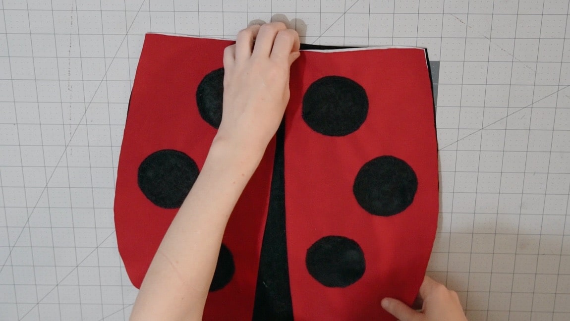 baste ladybug wings to one side of the bag